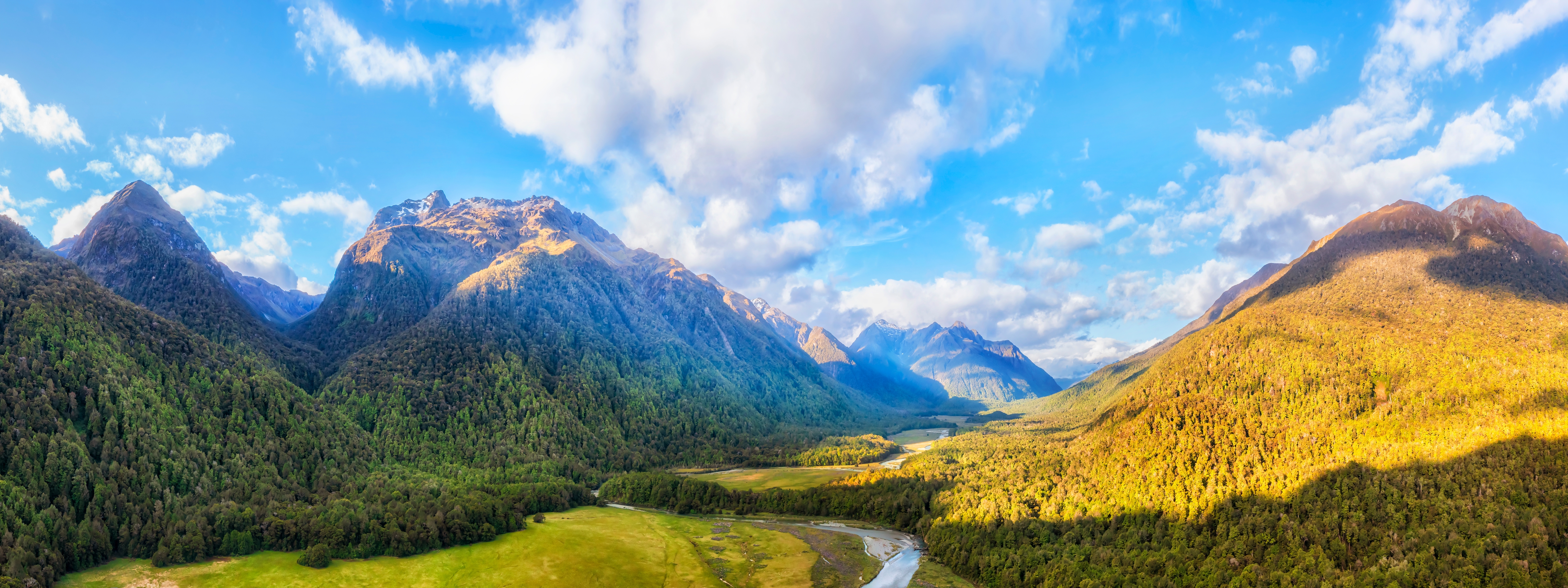 Luftpanorama over Eglinton Valley og floden i Fiordland National Park på New Zealands sydø med frodige grønne bjerge og snoet flod