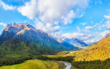 Luftpanorama over Eglinton Valley og floden i Fiordland National Park på New Zealands sydø med frodige grønne bjerge og snoet flod
