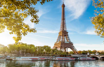 Eiffeltårnet set fra Seine-floden med turistbåde under solnedgang i Paris Frankrig