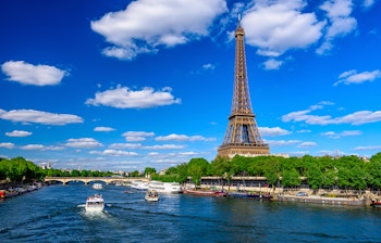 Det ikoniske Eiffeltårn og Seine-floden i Paris med smuk blå himmel og historiske broer - perfekt udsigt til din rejse til Frankrig