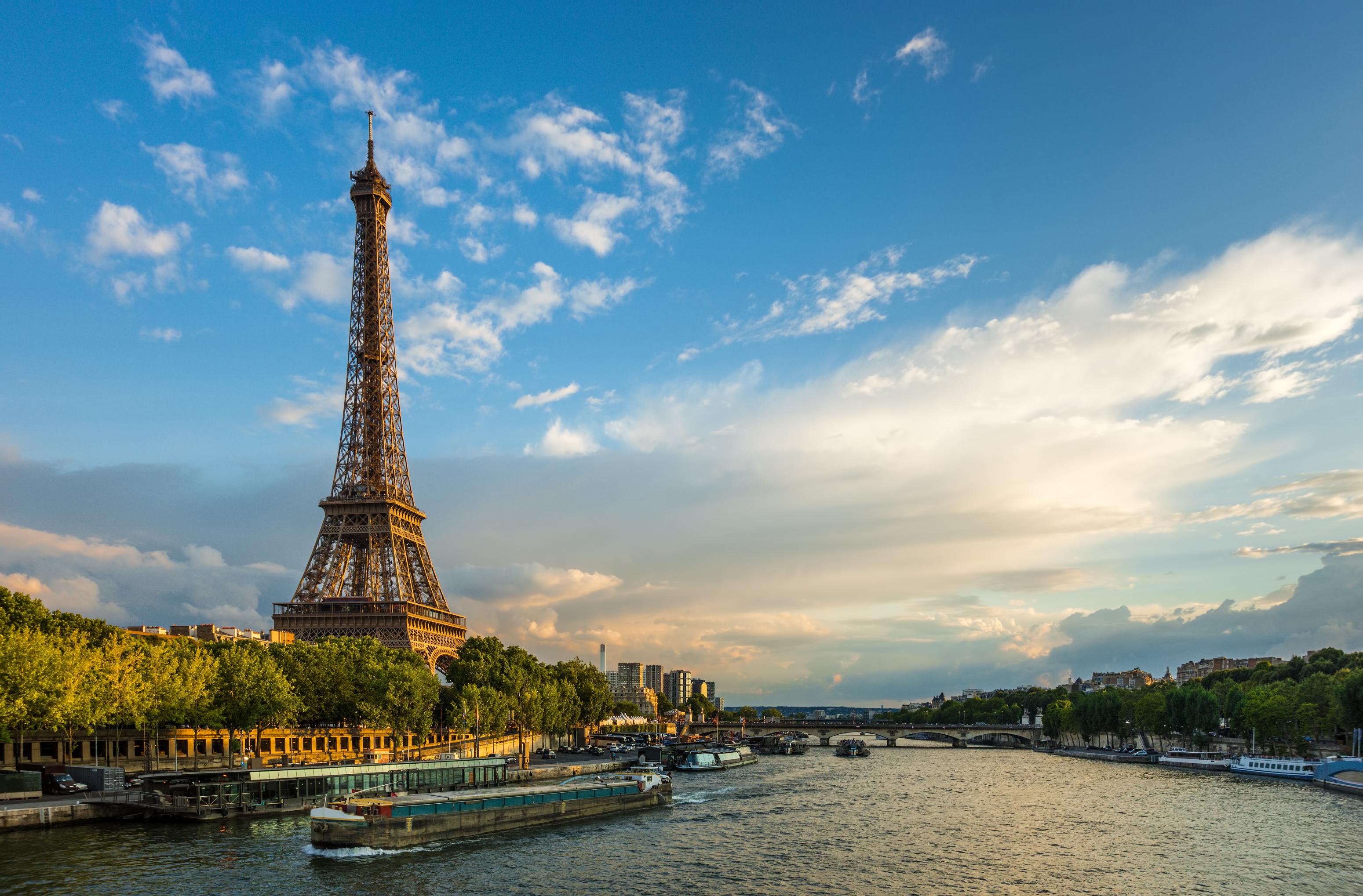 Smuk solnedgang over Eiffeltårnet og Seine-floden med turistbåde i Paris, Frankrigs romantiske hovedstad