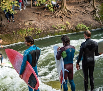 Surfer på den berømte stående bølge i Eisbach-floden ved Englischer Garten i München - en unik byoplevelse