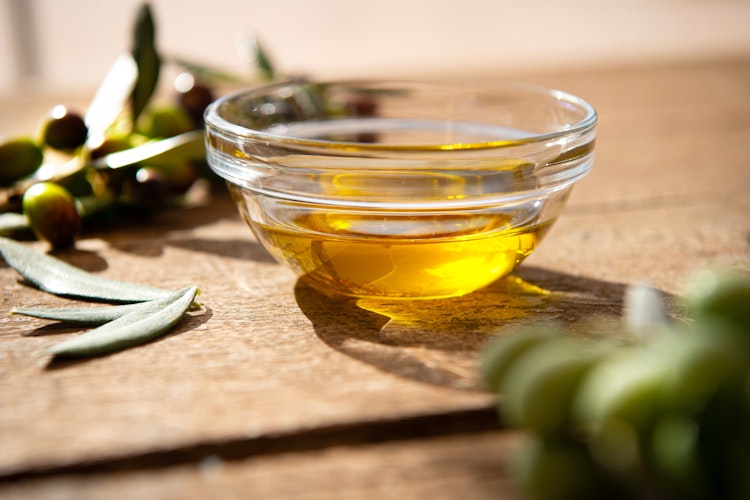 Gylden koldpresset olivenolie fra Spoleto i Umbrien serveret i glasskål med friske oliven - en lokal delikatesse vi smager under vores besøg på olivenoliemøllen