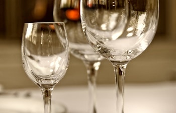 Elegant bordopdækning med krystalvinglas, fine tallerkener og stearinlys der skaber en luksuriøs stemning til gourmetoplevelser på restaurant