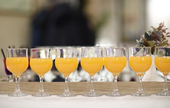 Elegante krystalglas med frisk appelsinjuice opstillet på række, der byder gæsterne velkommen til en luksuriøs ferieoplevelse