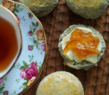 Traditionel engelsk cream tea med scone, clotted cream og marmelade serveret med te i dekorativ porcelænskop