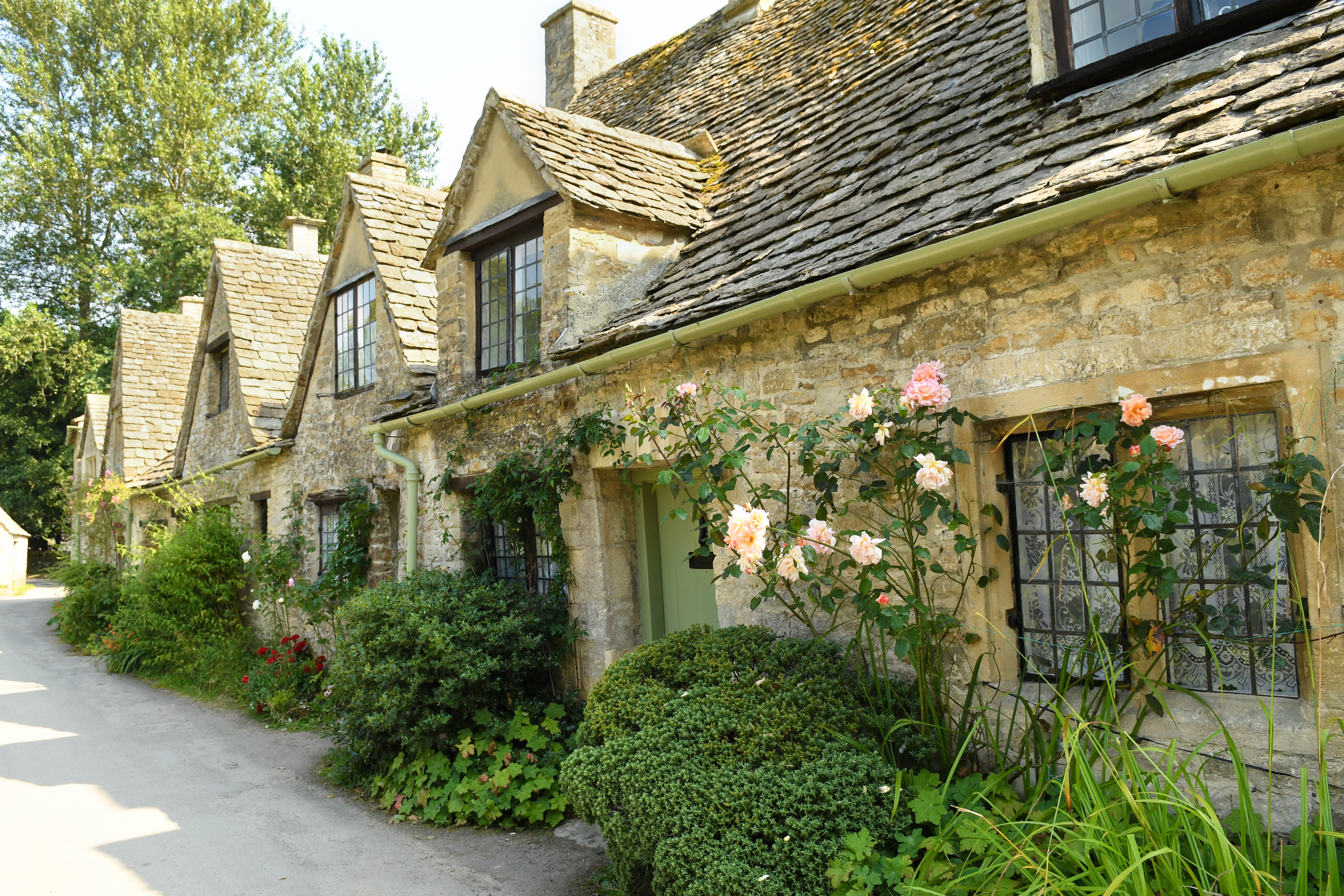 Traditionelle engelske stenhuse med klatreroser i pittoresk Cotswolds landsby