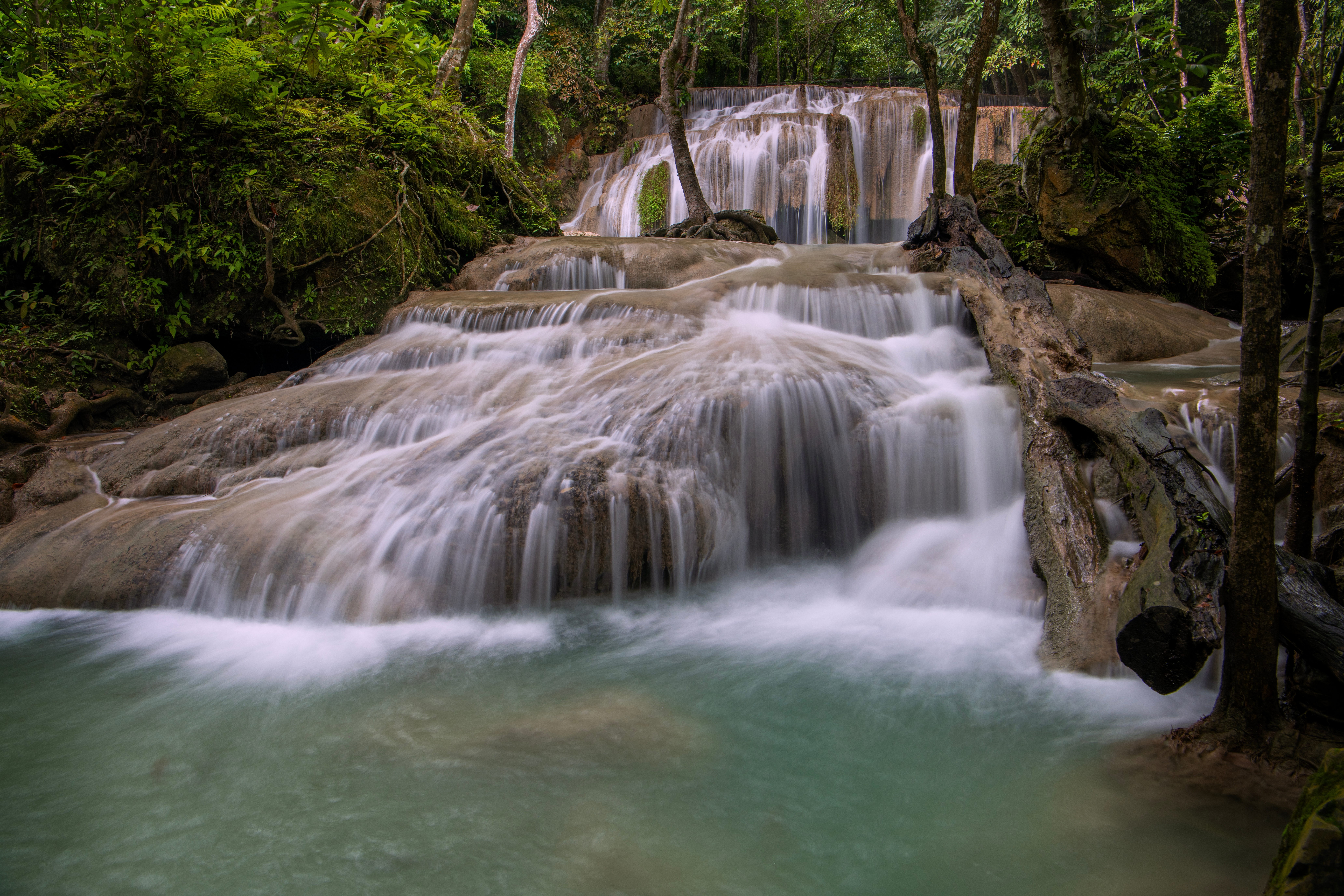 Naturskønt flertrins Erawan vandfald med turkisblåt vand og frodig tropisk regnskov i Kanchanaburi, Thailand