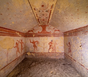 Farverige etruskiske gravmalerier i Tarquinia, Italien, der viser antikke fresker fra før-romersk tid i de historiske gravkamre