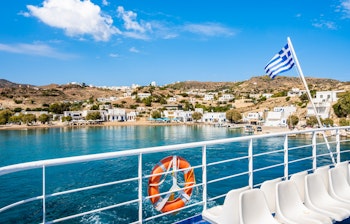 Færgedæk med græsk flag forlader Milos ø og sejler mod Kimolos i Kykladerne, Grækenland