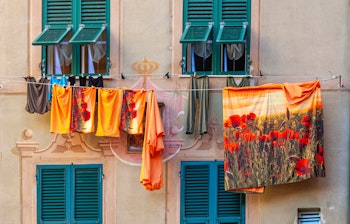 Farverig facade af et traditionelt hus med tøj til tørre i Camogli, en charmerende fiskerlandsby ved den liguriske kyst i Norditalien