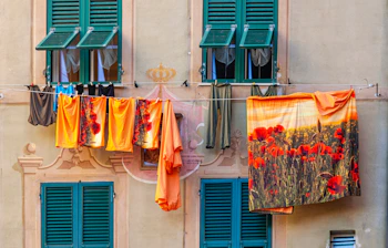 Farverig facade af et traditionelt hus med tøj til tørre i Camogli, en charmerende fiskerlandsby ved den liguriske kyst i Norditalien