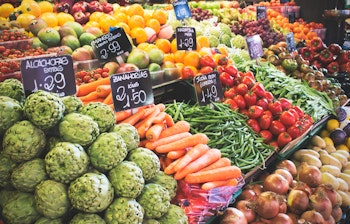 Farverig frugt- og grøntsagsbod på det berømte La Boqueria marked i Barcelona med friske lokale råvarer og prisskiltning