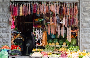 Traditionel georgisk markedsbod i Tbilisi med friske frugter, grøntsager og hængende churchkhela-slik