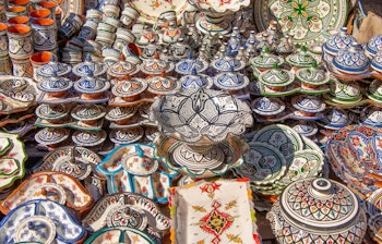 Farverige marokkanske keramikprodukter udstillet i en traditionel souk, håndlavet kunsthåndværk og souvenirs fra Marokko