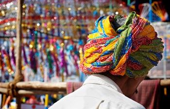 Traditionelt klædt indisk mand med farverig turban på det livlige marked i Pushkar, Rajasthan