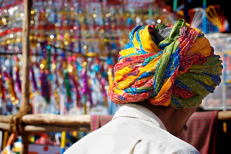 Traditionelt klædt indisk mand med farverig turban på det livlige marked i Pushkar, Rajasthan