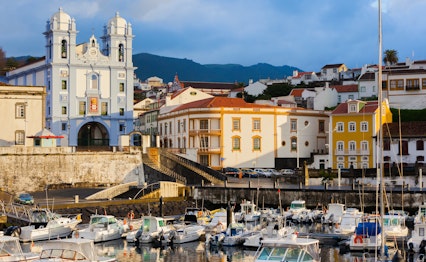 Farverig udsigt over Angra do Heroismo på Terceira øen, Azorerne. UNESCO verdensarv med traditionel arkitektur og havn fotograferet i det tidlige morgenlys efter storm.