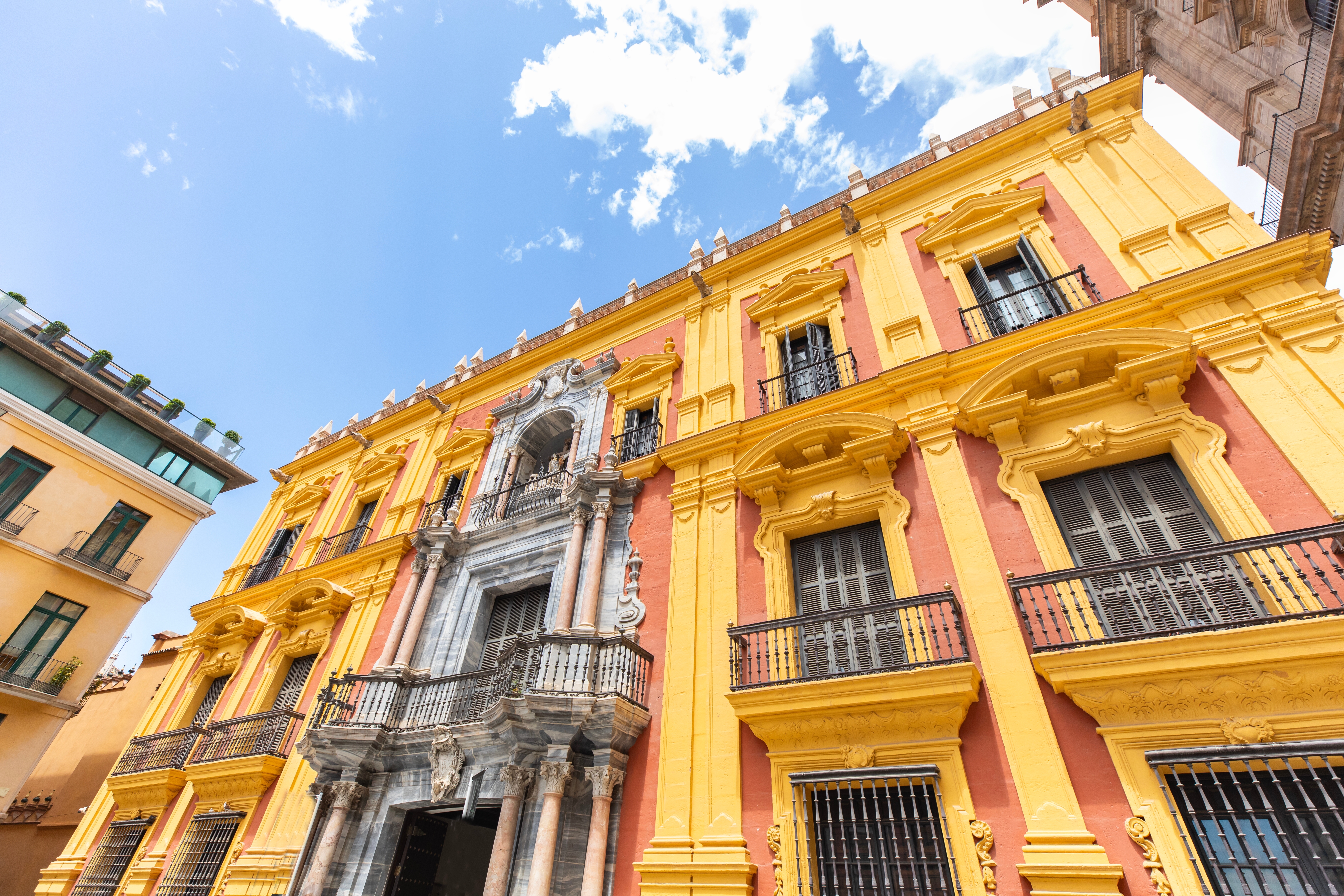 Charmerende farverig gade i det historiske kvarter i Malaga med blomstrende bougainvillea og traditionel andalusisk arkitektur