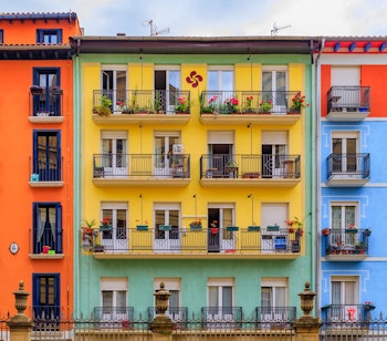 Farverige historiske bygninger med blomsterdekorerede balkoner i Pamplonas gamle bydel, Casco Viejo, kendt for tyreløbet