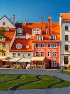 Charmerende farverige historiske bygninger på torvet i Rigas gamle bydel, der viser Letlands rige arkitektoniske arv under en klar blå himmel