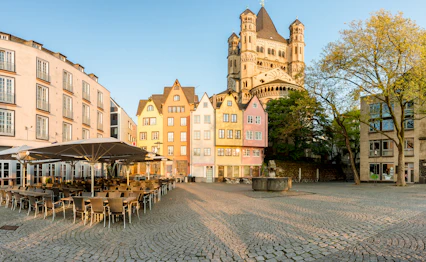 Farverige traditionelle huse ved Sankt Martin's kirke i Köln, perfekt til en kulturfyldt storbyferie i Tyskland