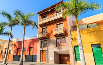 Charmerende farverige huse og palmtræer langs gaden i Puerto de la Cruz på Tenerife, De Kanariske Øer