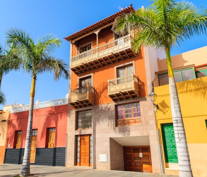 Charmerende farverige huse og palmtræer langs gaden i Puerto de la Cruz på Tenerife, De Kanariske Øer