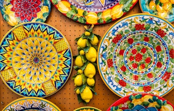 Farverige håndlavede keramikprodukter fra Positano ved Amalfikysten i Italien, der viser traditionelt lokalt kunsthåndværk og souvenirs