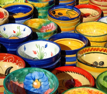 Farverige håndlavede keramiske fade og skåle med traditionelle mønstre udstillet på det livlige gademarked i Fuengirola, Costa del Sol, Andalusien, Spanien