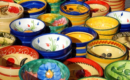 Farverige håndlavede keramiske fade og skåle med traditionelle mønstre udstillet på det livlige gademarked i Fuengirola, Costa del Sol, Andalusien, Spanien