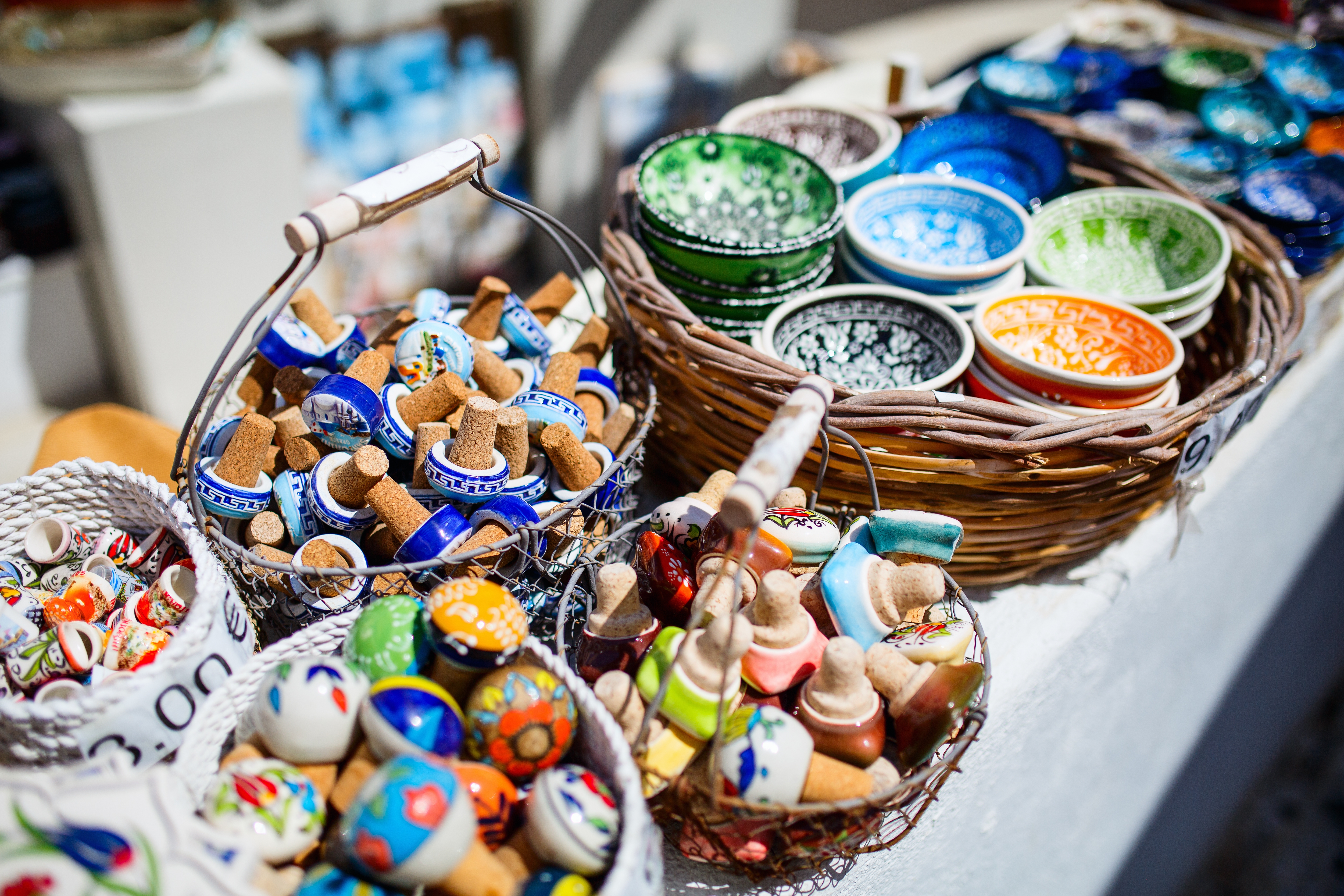 Farverige håndlavede keramiske souvenirs på et traditionelt marked i Grækenland med skåle, tallerkener og dekorative genstande