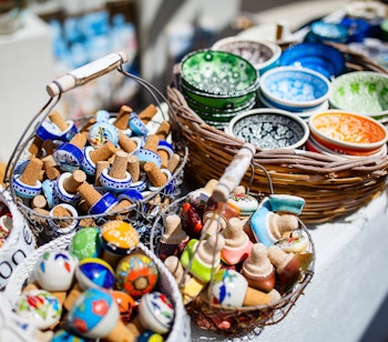 Farverige håndlavede keramiske souvenirs på et traditionelt marked i Grækenland med skåle, tallerkener og dekorative genstande