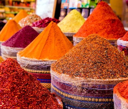 Farverige krydderier på det traditionelle egyptiske bazaar i Istanbul, Tyrkiet, med smukt arrangerede røde, gule og orange krydderier