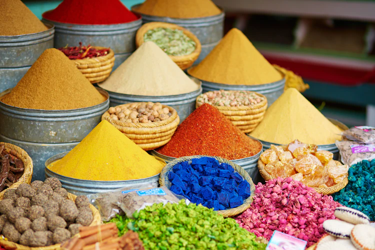 Farverige krydderier i bunker på et traditionelt marokkansk marked (souk) i Marrakech med paprika, safran og andre nordafrikanske specialiteter