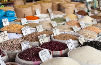 Traditionelt marked i Tbilisi med farverige krydderier og bælgfrugter i sække med lokale prisskilte