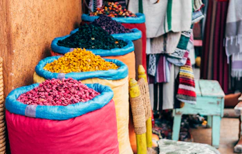 Farverige krydderisække på et traditionelt marked i Marrakech, Marokko - en sanselig oplevelse på rejsen til Nordafrika