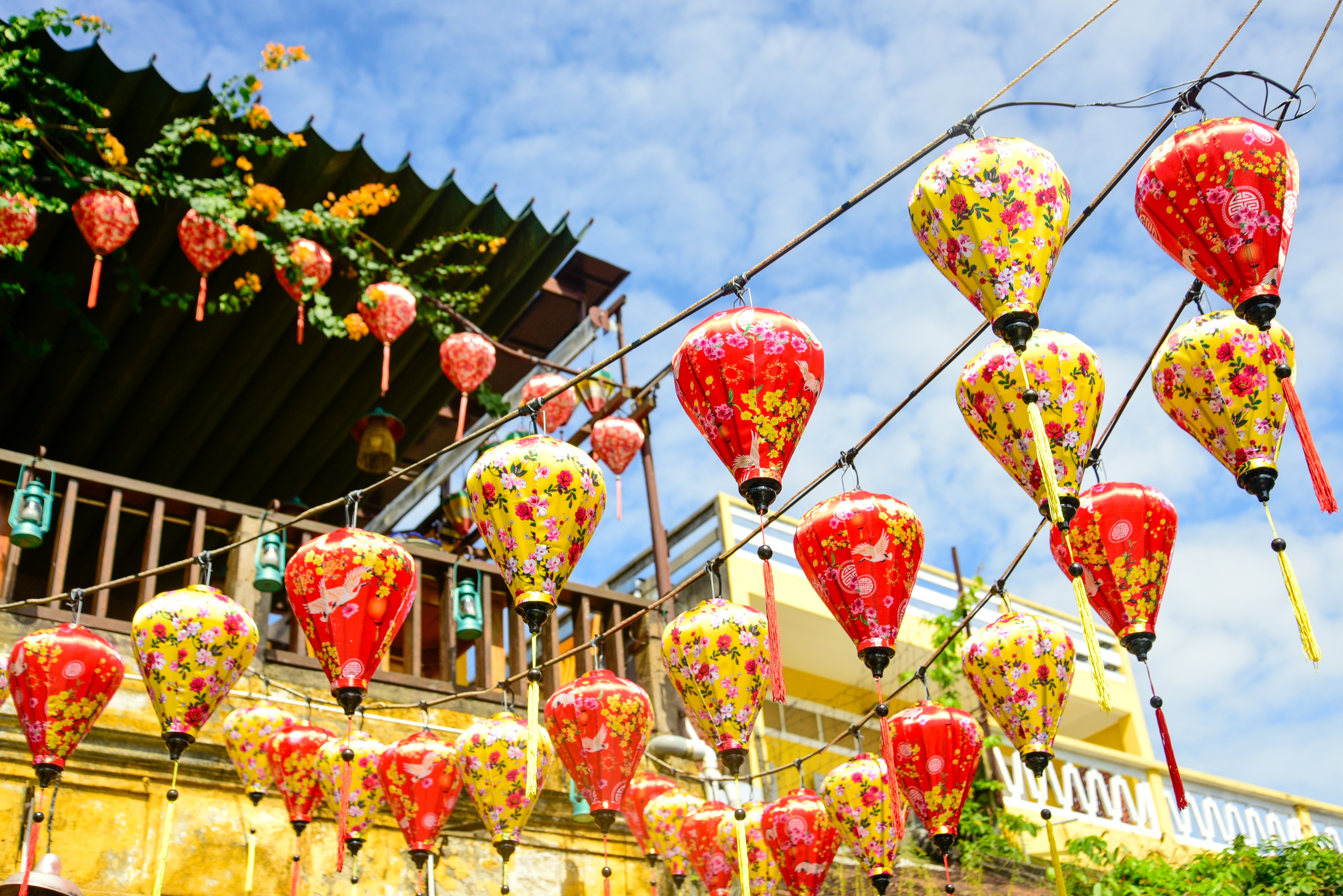 Farverige silkelanterner hænger over de historiske gader i Hoi An Old Town, Vietnam