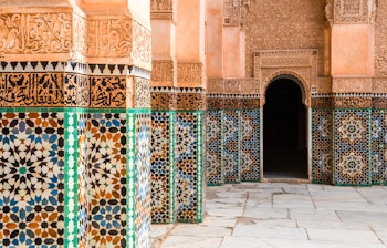 Farverige traditionelle mosaikfliser i Ben Youssef Medersa gården i Marrakech, der viser Marokkos rige kulturarv og islamisk kunst