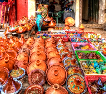 Farverige terracotta tajine-potter med dekorative mønstre på et marked i Fes' gamle medina i Marokko