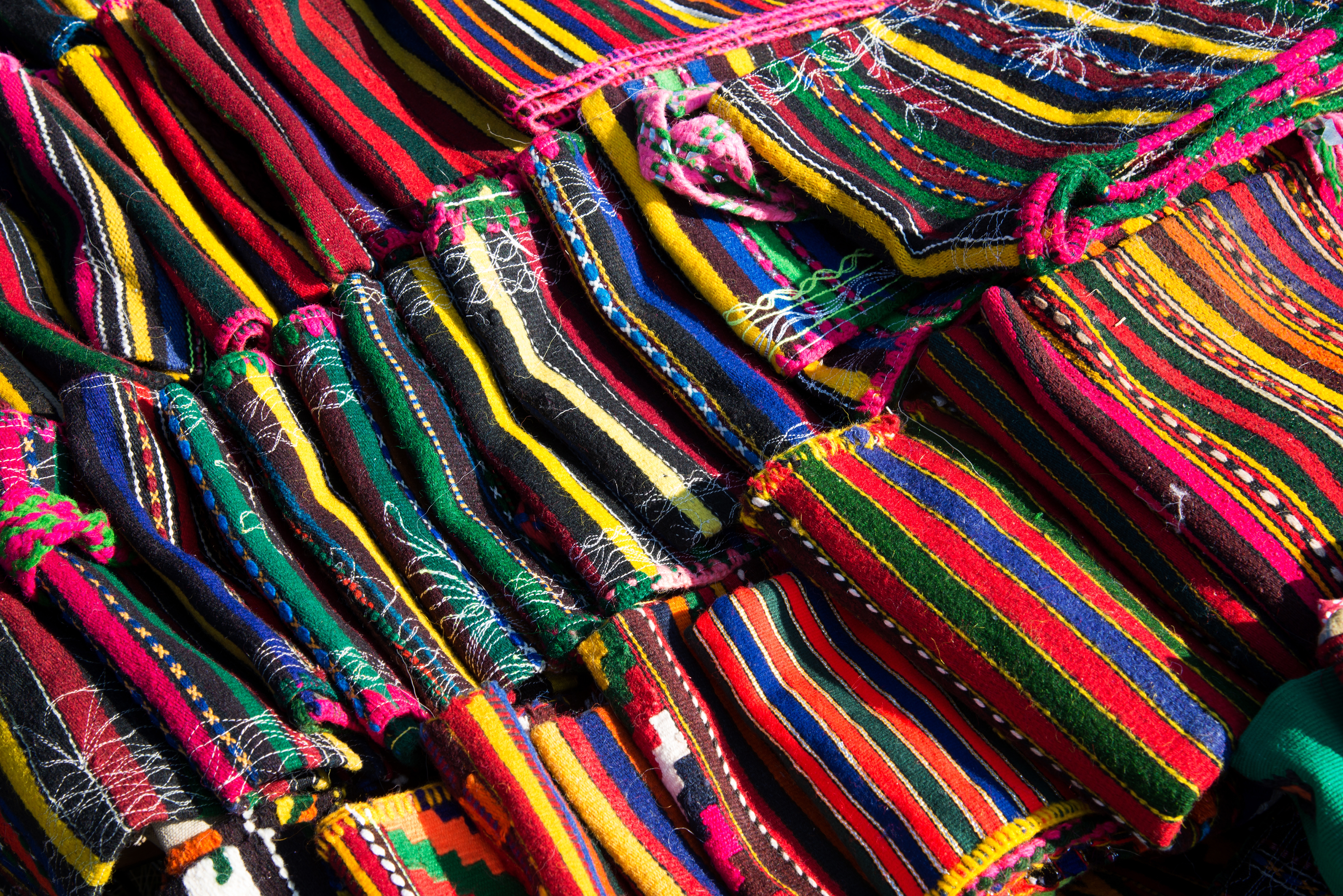 Farverige traditionelle håndvævede tekstiler og tæpper med etniske mønstre fra Bulgarien