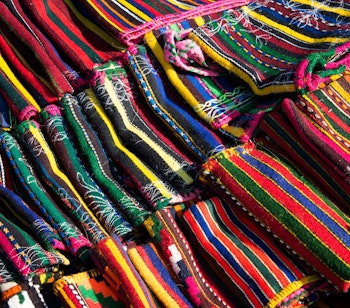 Farverige traditionelle håndvævede tekstiler og tæpper med etniske mønstre fra Bulgarien