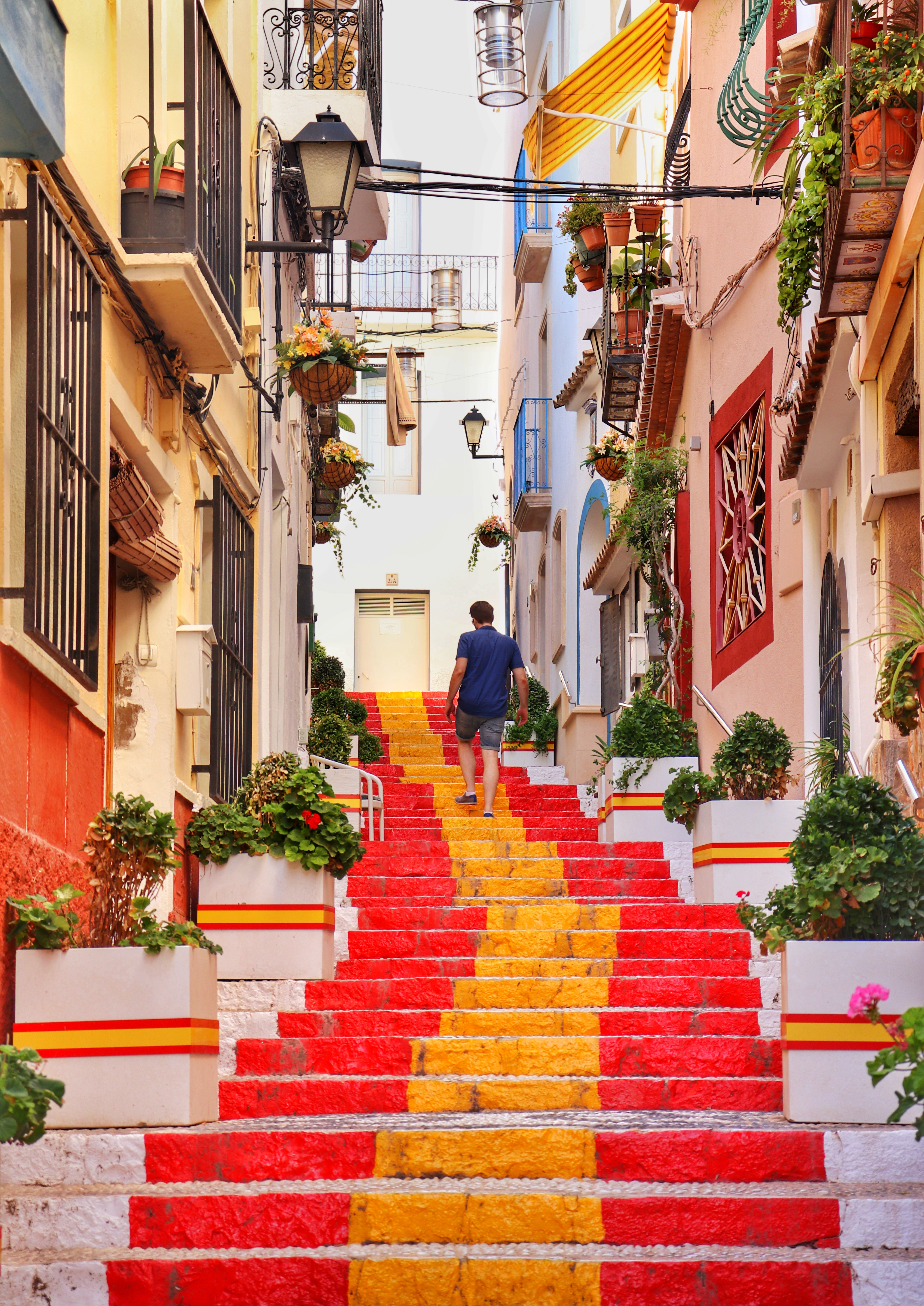 Maleriske røde trapper i den gamle bydel i Alicante med traditionel spansk arkitektur og middelhavsstemning