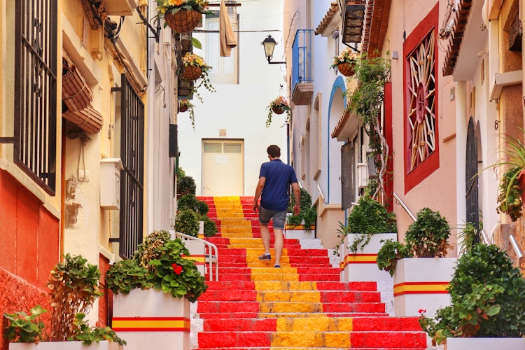 Maleriske røde trapper i den gamle bydel i Alicante med traditionel spansk arkitektur og middelhavsstemning