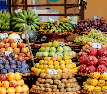 Farverig udstilling af friske eksotiske frugter på det lokale marked i Funchal, Madeira med pitaya, kiwi og bananer