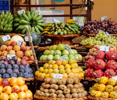 Farverig udstilling af friske eksotiske frugter på det lokale marked i Funchal, Madeira med pitaya, kiwi og bananer