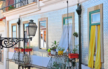 Traditionelle farverige vinduer på historiske bygninger i Alfama-kvarteret i Lissabon viser Portugals unikke arkitektoniske charme