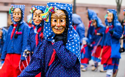 Farverigt karnevalsoptog med traditionelle kostumer og masker under Fasnacht-fejringen i Sydtyskland
