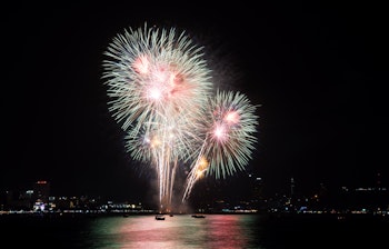 Farverigt blåt, hvidt og rødt fyrværkeri lyser op på nattehimlen til fejring af specielle rejseoplevelser