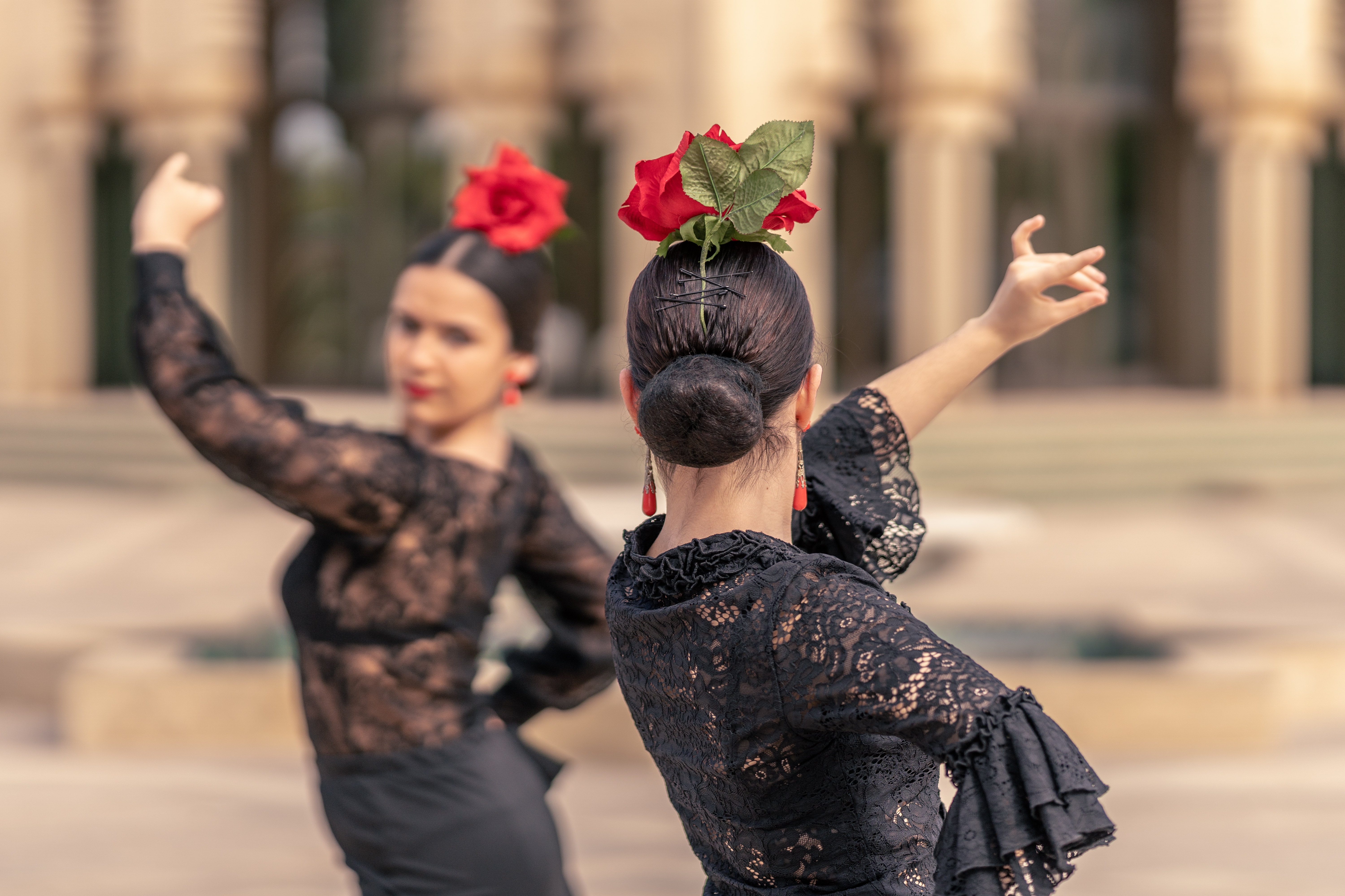 Traditionelle flamenco dansere i sorte blondekjoler med røde roser optræder i Sevilla, Andalusien